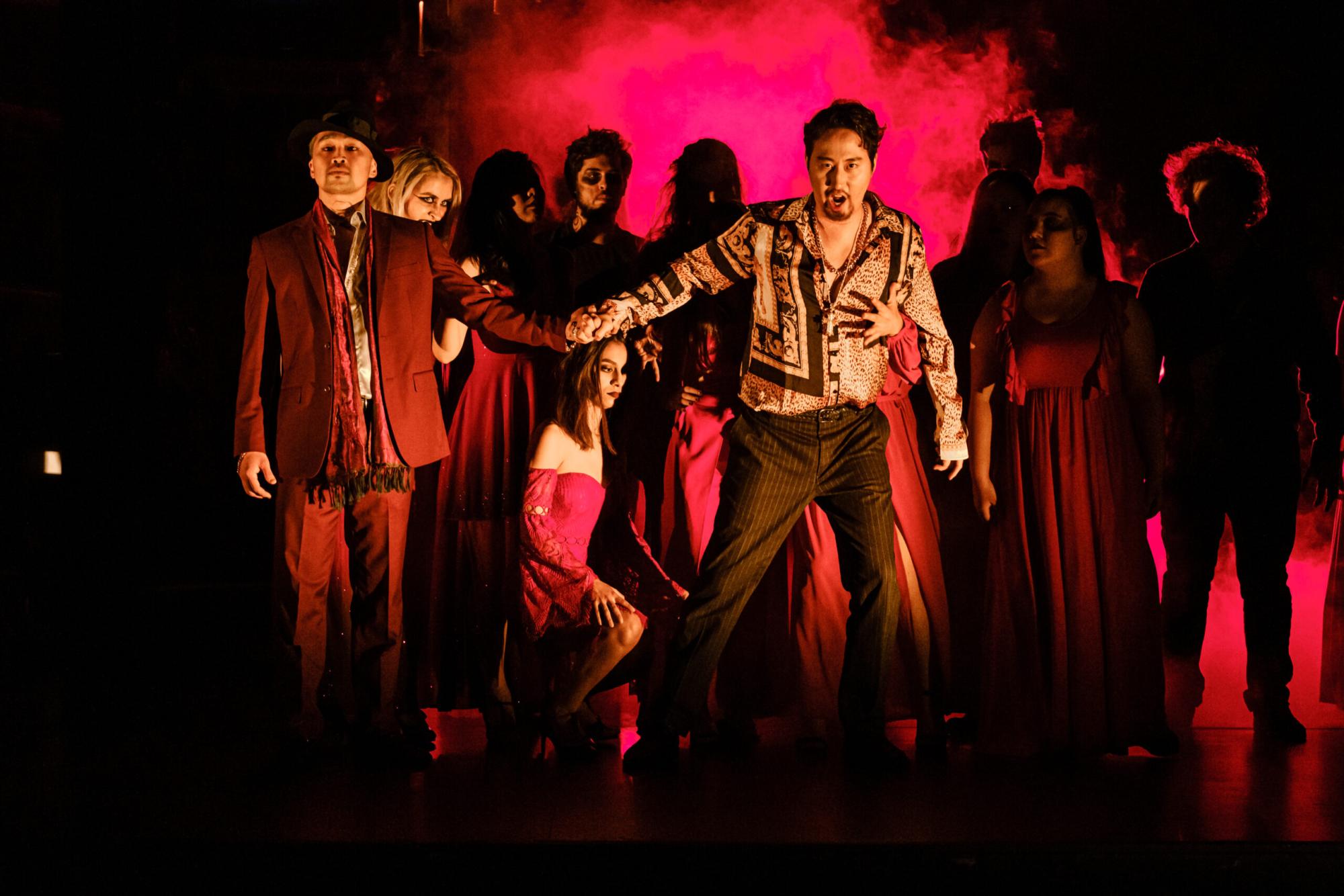 production photo, a man singing while demons surround him