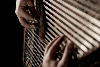 Close up photo of hands playing a qanun