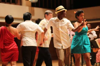 members of the Hispanic Caribbean Ensemble dance on stage during a performance