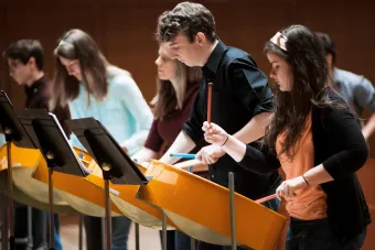 A line of Steel pan drummers perform in Bates Recital Hall