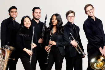 A group of symphony band students look confidently at the viewer.